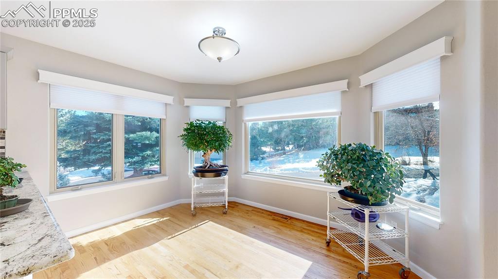 Image 10 of 34: Sitting room with light wood-type flooring, baseboards, and plenty of natur