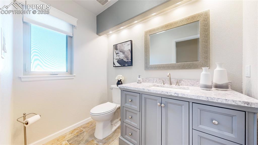 Image 13 of 34: Half bath with toilet, vanity, and baseboards
