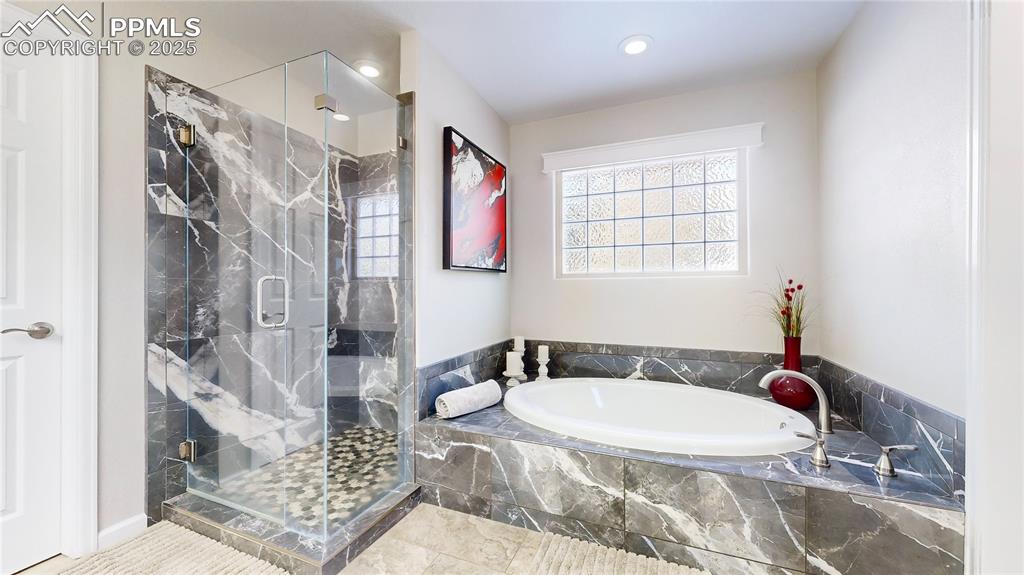 Image 15 of 34: Bathroom featuring a bath, a marble finish shower, and recessed lighting