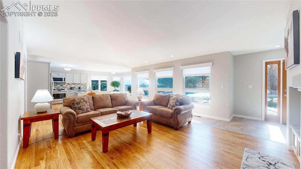 Image 2 of 34: Living room with light wood-style flooring, recessed lighting, and baseboar