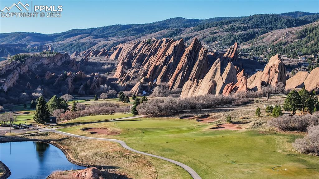 Image 31 of 34: View of mountain backdrop featuring a local golf course and a nearby body o