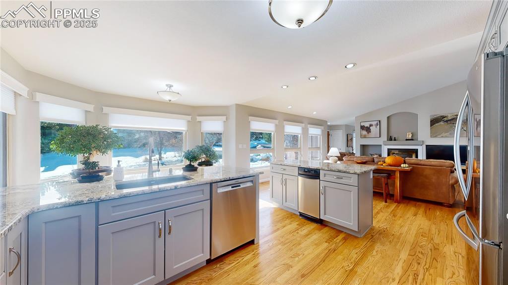 Image 8 of 34: Kitchen featuring appliances with stainless steel finishes, a fireplace, a