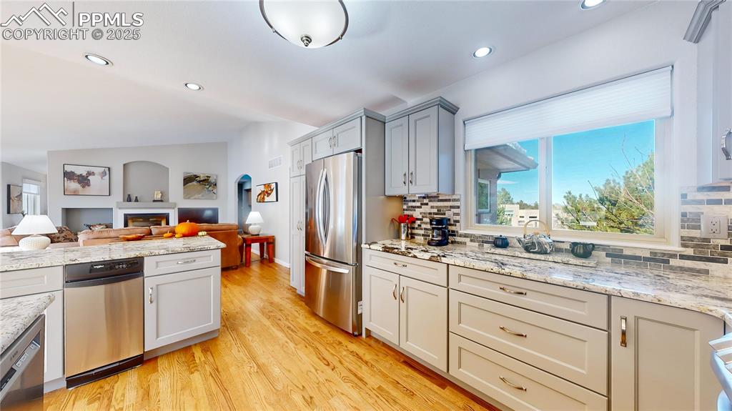 Image 9 of 34: Kitchen with appliances with stainless steel finishes, open floor plan, tas