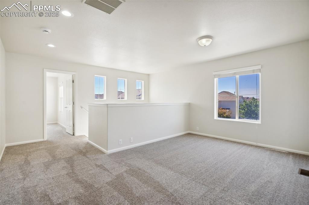 Image 19 of 28: Carpeted empty room with a smoke detector and recessed lighting