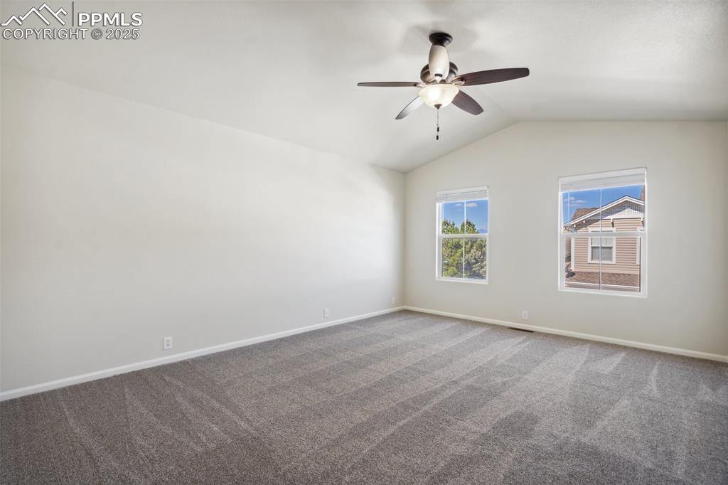 Image 20 of 28: Carpeted empty room featuring ceiling fan and vaulted ceiling