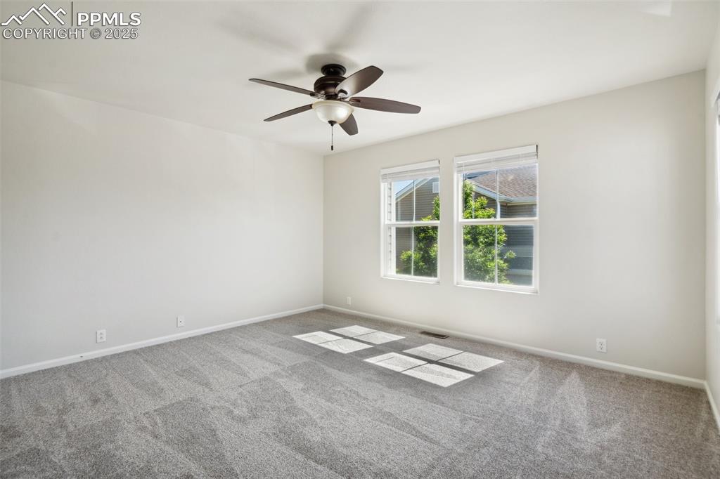 Image 24 of 28: Empty room featuring ceiling fan and carpet floors