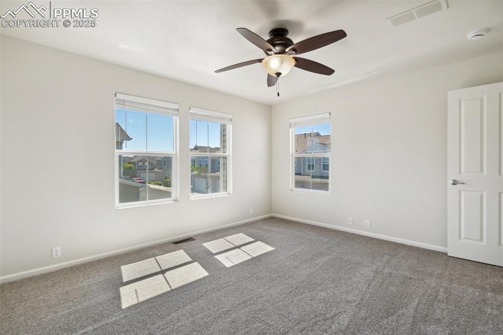 Image 25 of 28: Empty room with carpet and ceiling fan