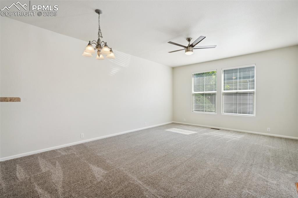 Image 3 of 28: Carpeted empty room featuring a ceiling fan and a chandelier
