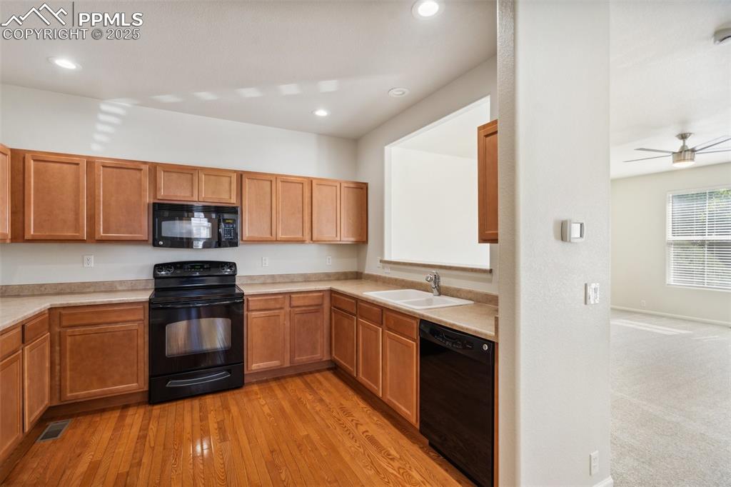 Image 9 of 28: Kitchen featuring black appliances, light countertops, recessed lighting, l