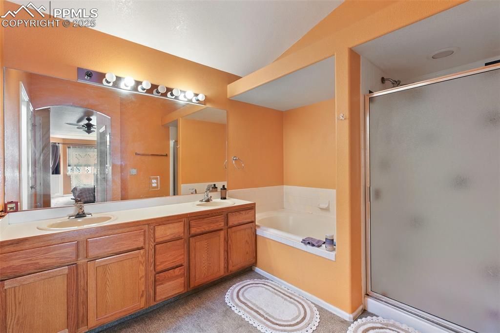 Image 21 of 29: Ensuite bathroom featuring a stall shower, a ceiling fan, a garden tub, and