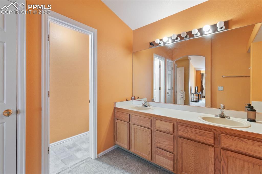 Image 22 of 29: Full bathroom featuring double vanity and lofted ceiling