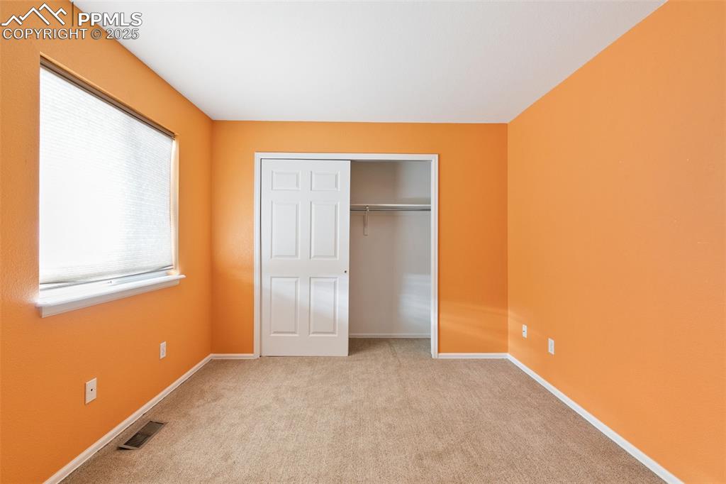 Image 24 of 29: Unfurnished bedroom featuring light colored carpet and a closet