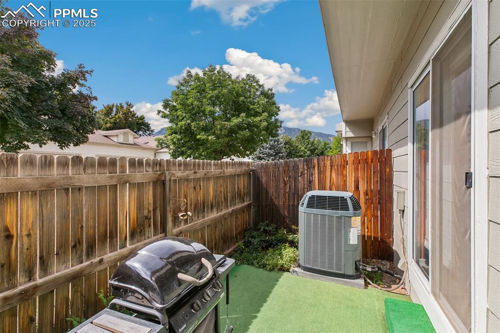 Image 28 of 29: Fenced backyard with a patio area