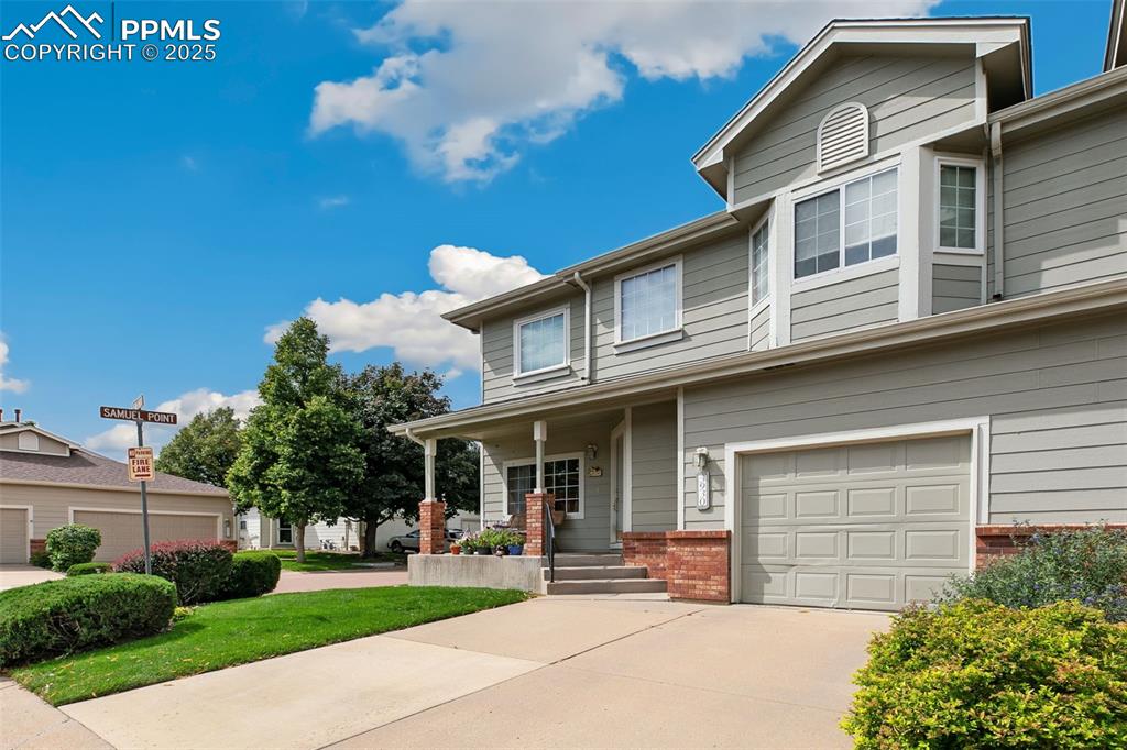 Image 3 of 29: View of front of house with a porch, driveway, brick siding, and an attache