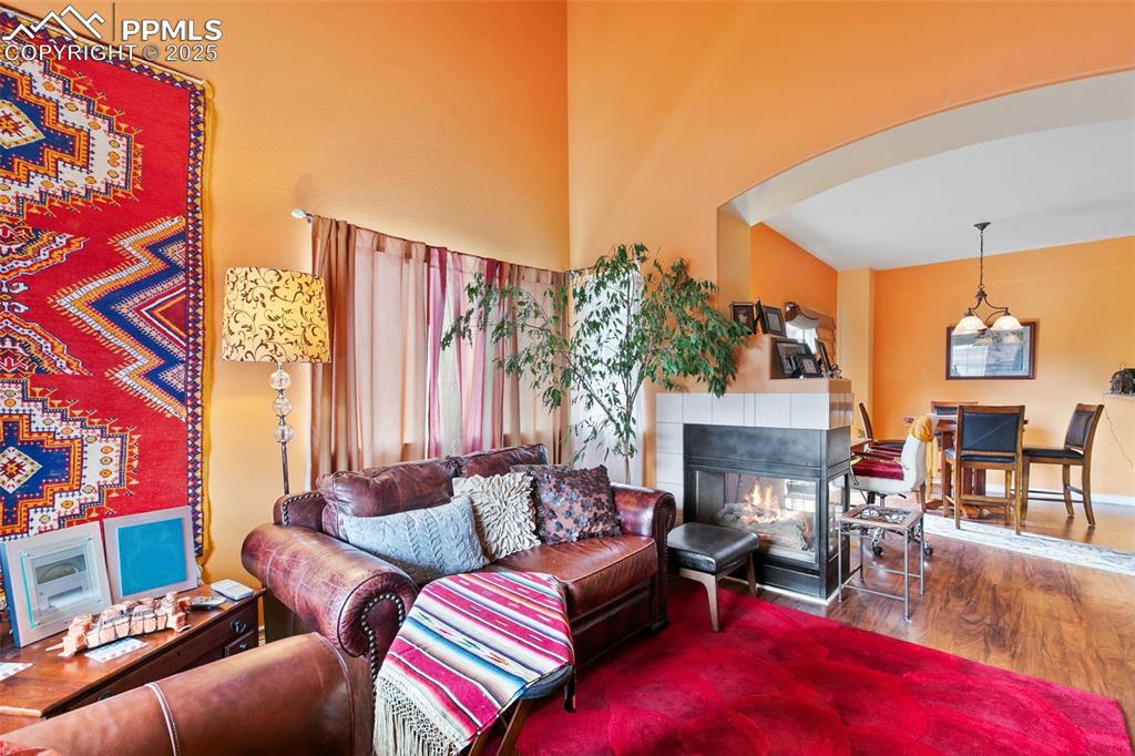 Image 4 of 29: Living area featuring wood finished floors and a tile fireplace