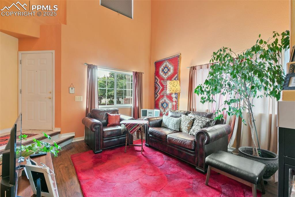 Image 5 of 29: Living room featuring wood finished floors and a towering ceiling