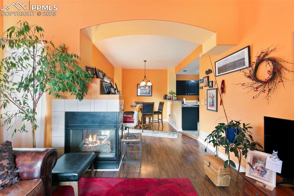 Image 7 of 29: Living room featuring dark wood-style flooring and a tile fireplace