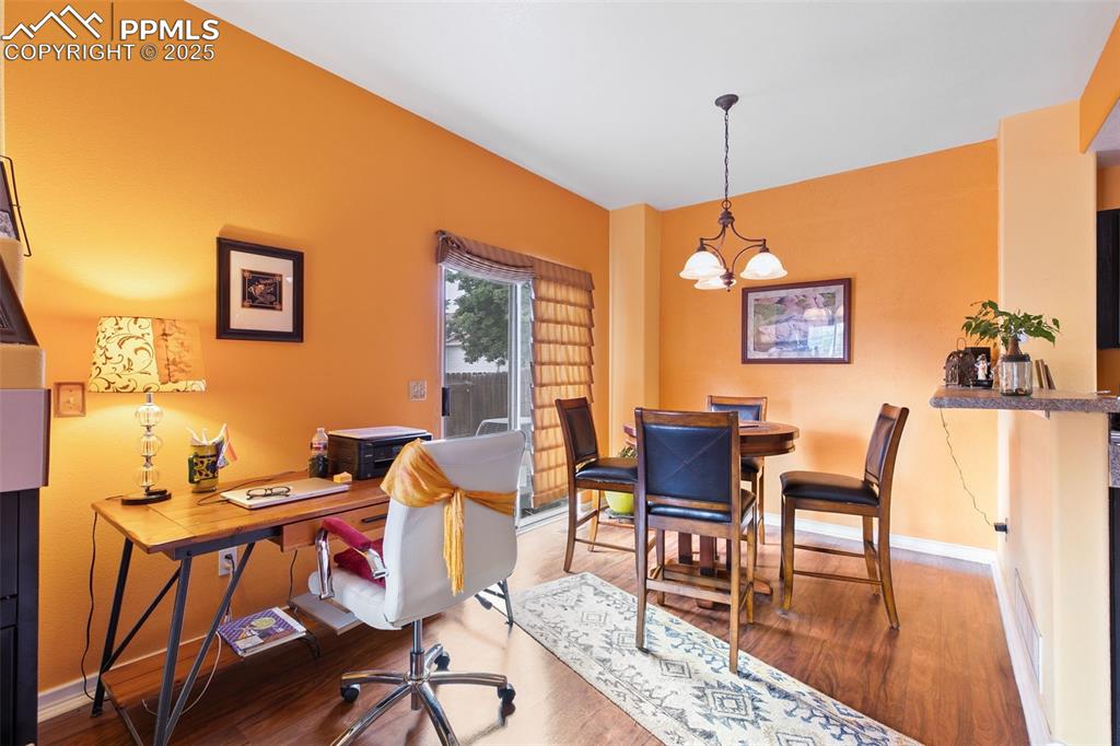 Image 9 of 29: Office featuring wood finished floors and a chandelier