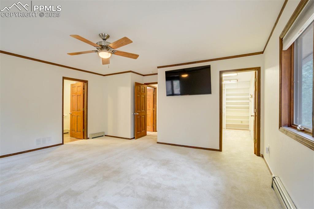 Image 18 of 48: Unfurnished bedroom with ensuite bath, crown molding, baseboard heating, li