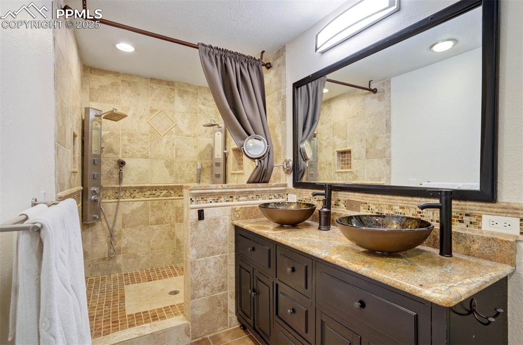 Image 19 of 48: Full bathroom with a walk in shower, double vanity, recessed lighting, back