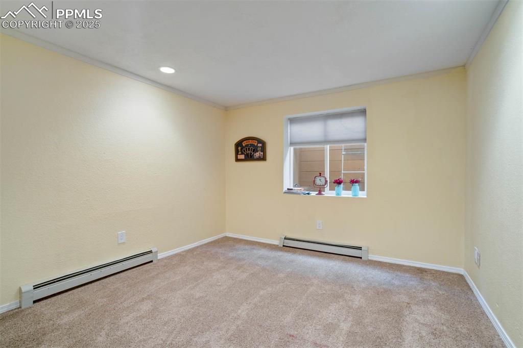 Image 31 of 48: Empty room with a baseboard heating unit, ornamental molding, light colored