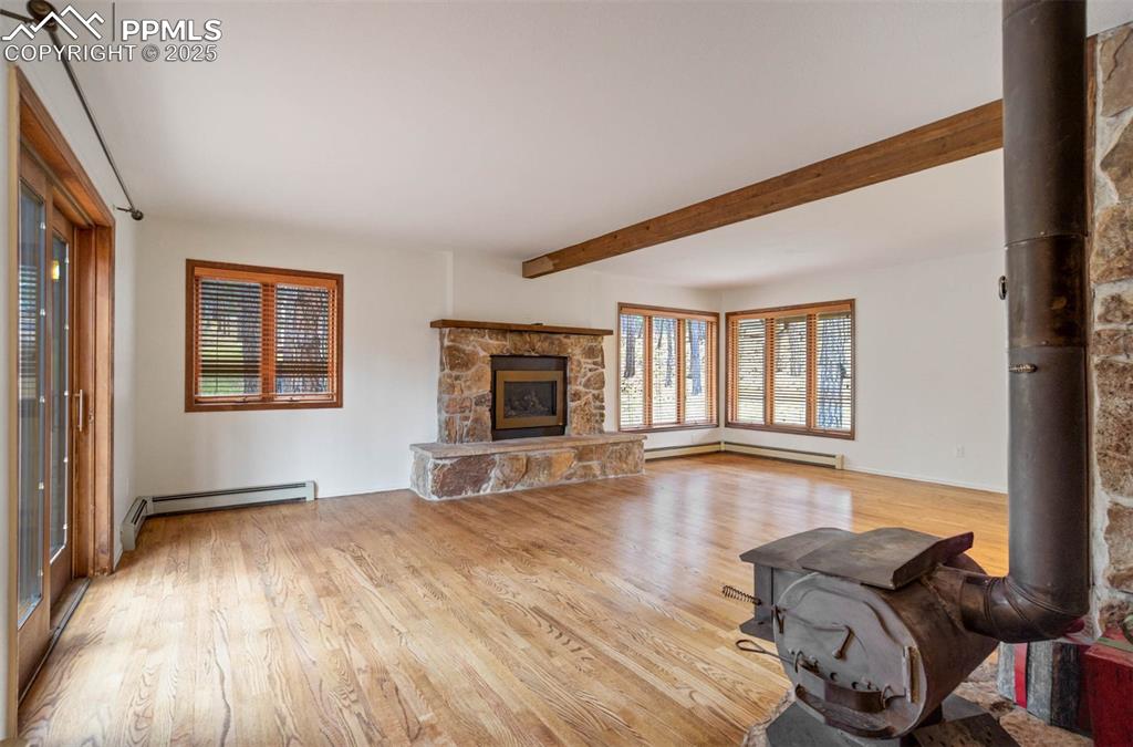 Image 42 of 48: Living room featuring a wood stove, light wood-style floors, healthy amount