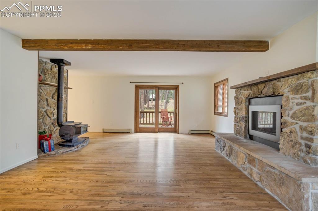 Image 8 of 48: Unfurnished living room featuring a wood stove, light wood-style flooring, 