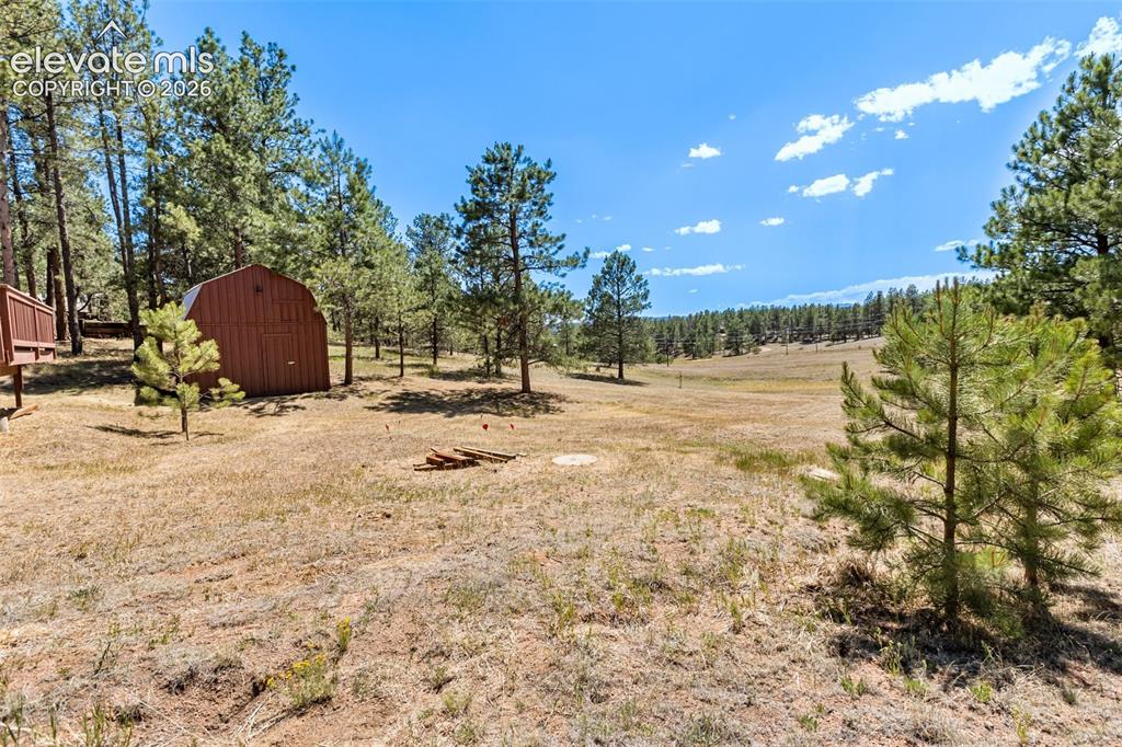 Image 18 of 22: View from side of property to include oversized Shed with workshop