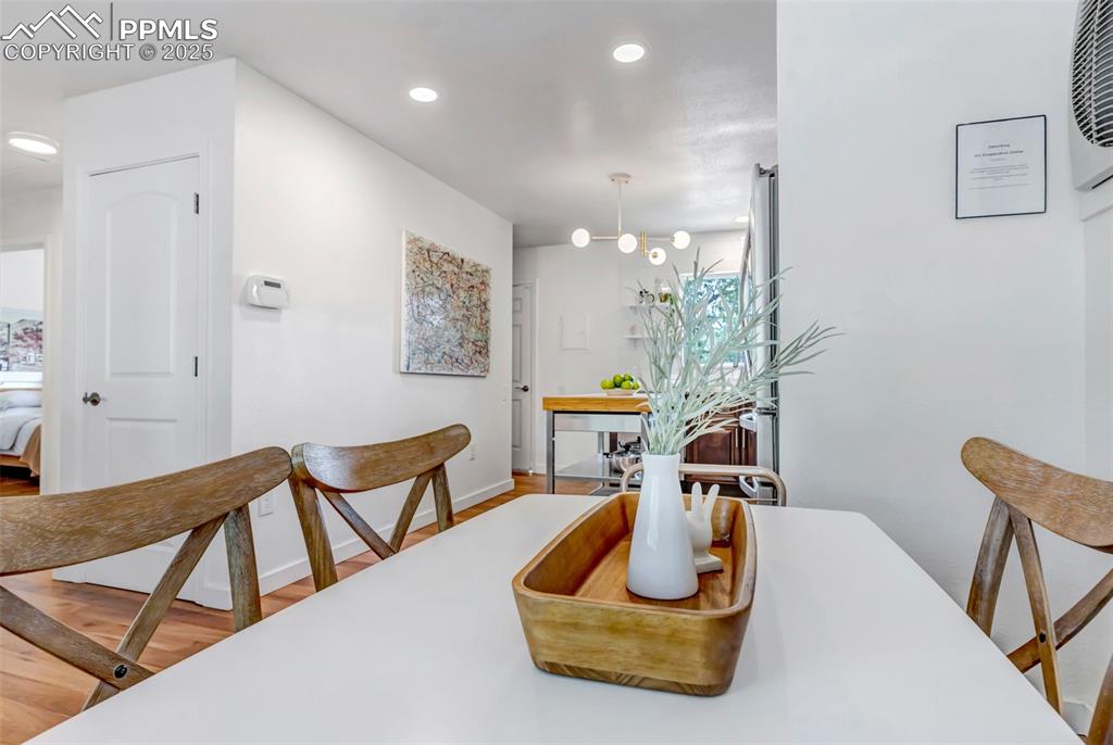 Image 10 of 35: Dining space with wood finished floors and recessed lighting