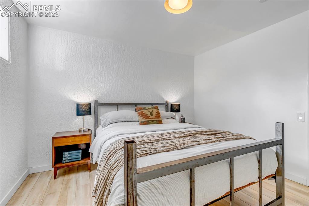 Image 17 of 35: Bedroom featuring a textured wall and light wood finished floors