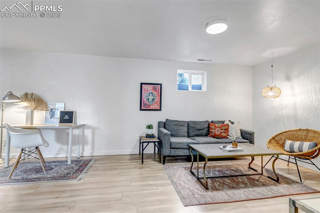 Image 18 of 35: Living room featuring a textured wall and light wood-type flooring