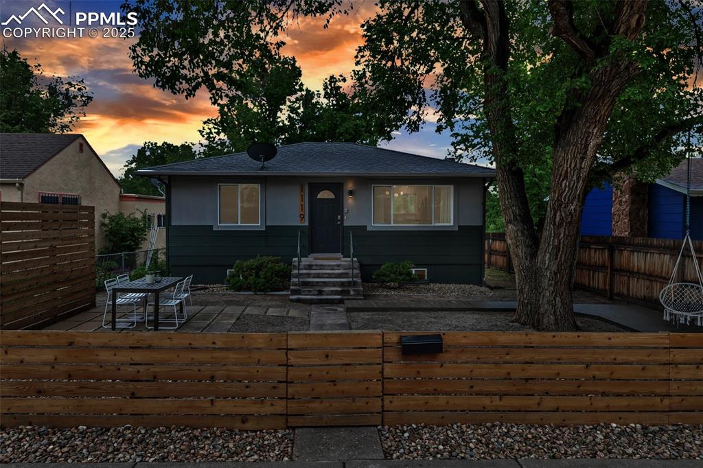 Image 2 of 35: Bungalow featuring a fenced front yard and a shingled roof
