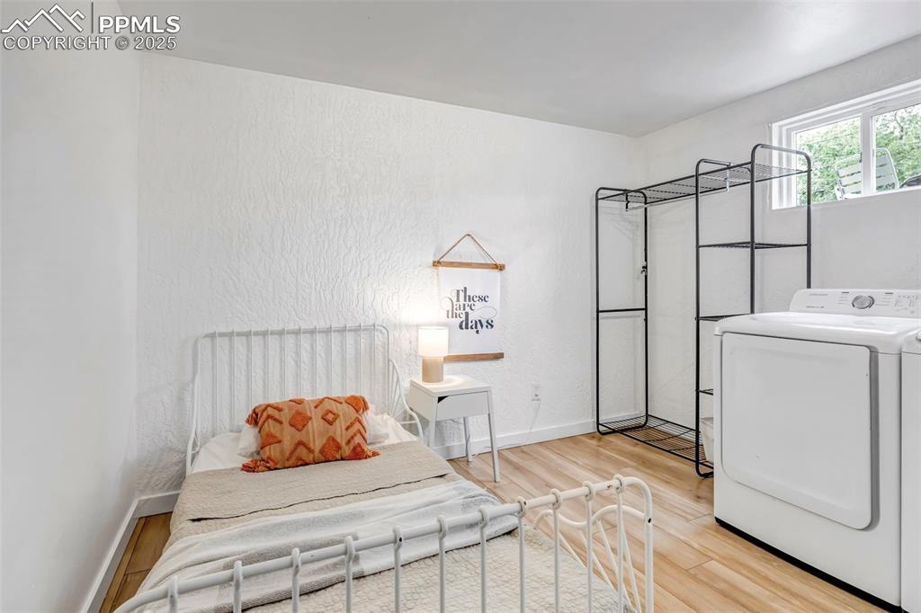 Image 24 of 35: Bedroom in basement that doubles as a laundry room
