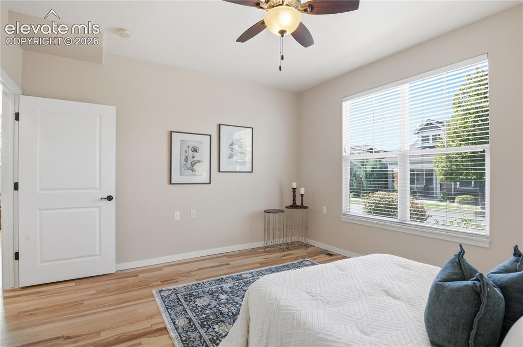 Image 15 of 27: High ceilings with a ceiling fan, wood-finish flooring, and a large window