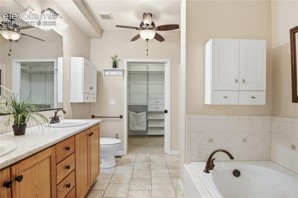 Image 17 of 27: Dual vanity with wood-finish cabinetry and integrated sinks, complemented b