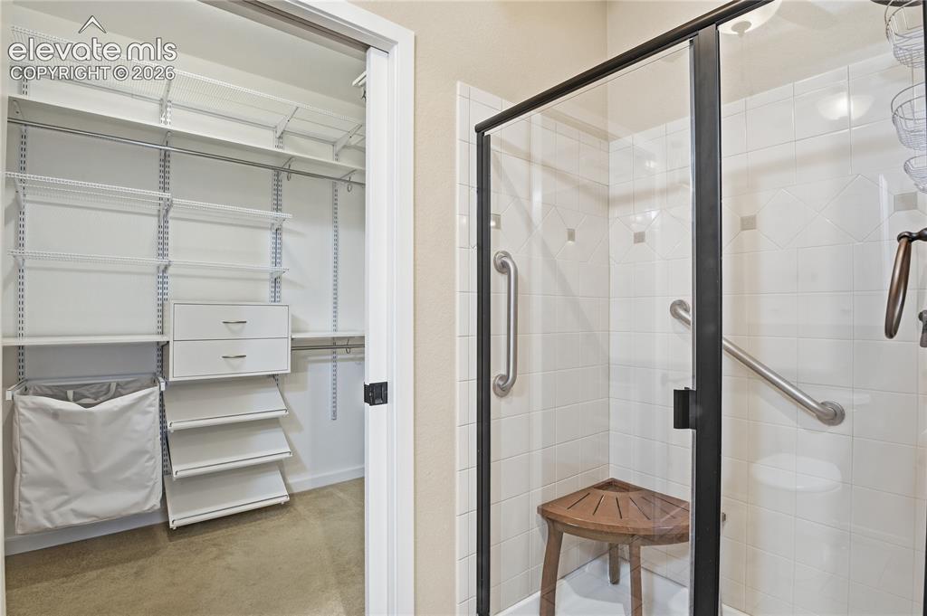 Image 18 of 27: Custom closet system with white shelving and built-in drawers