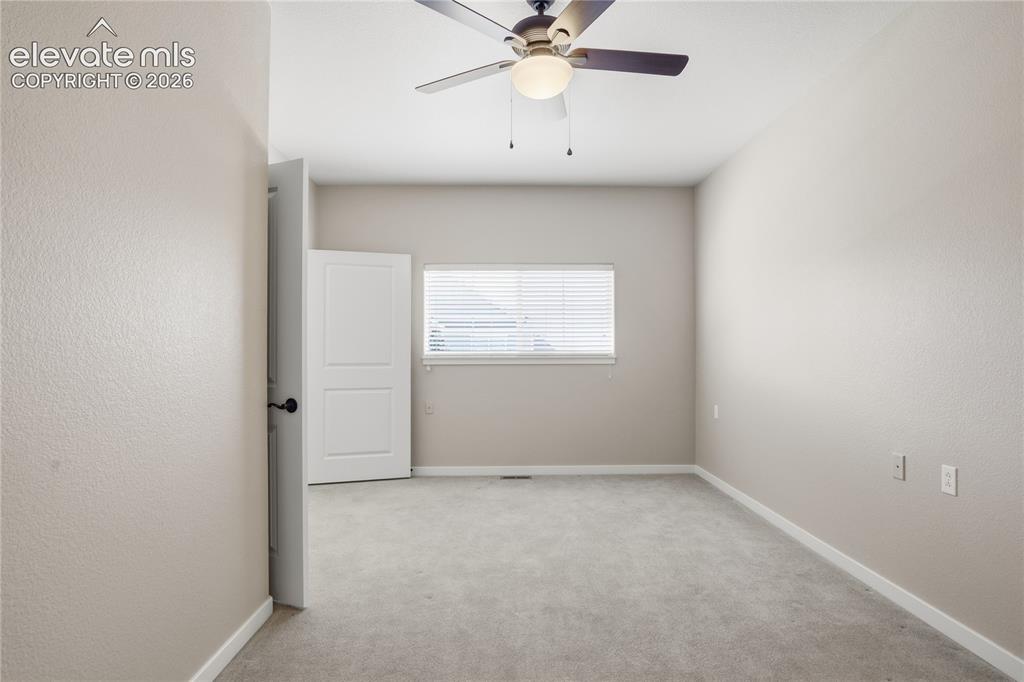 Image 22 of 27: Plush grey carpeting, neutral wall finishes, single window with blinds, cei