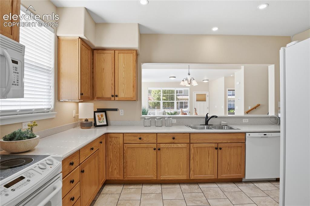 Image 9 of 27: Kitchen featuring wood cabinetry, light-toned countertops, a stainless stee