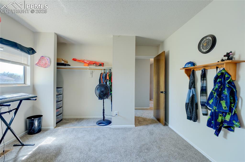 Image 21 of 35: Bedroom with carpet, a closet, and a textured ceiling