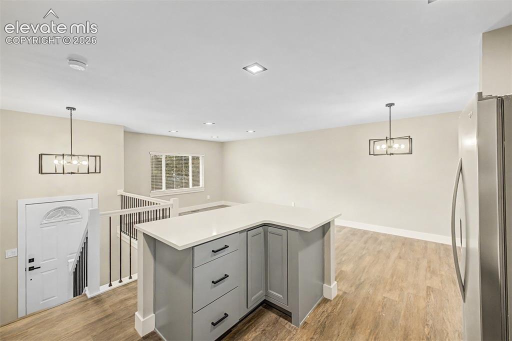 Image 14 of 36: Open-concept living space with wood-finish flooring, recessed lighting, and