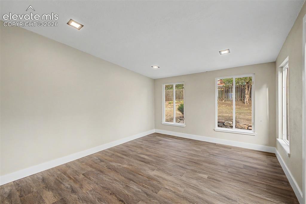 Image 16 of 36: Recessed ceiling lighting, wood-finish flooring, multiple windows, and ligh