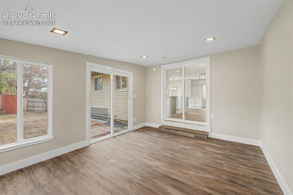 Image 17 of 36: Wood-finish flooring, recessed lighting, and a light neutral wall color