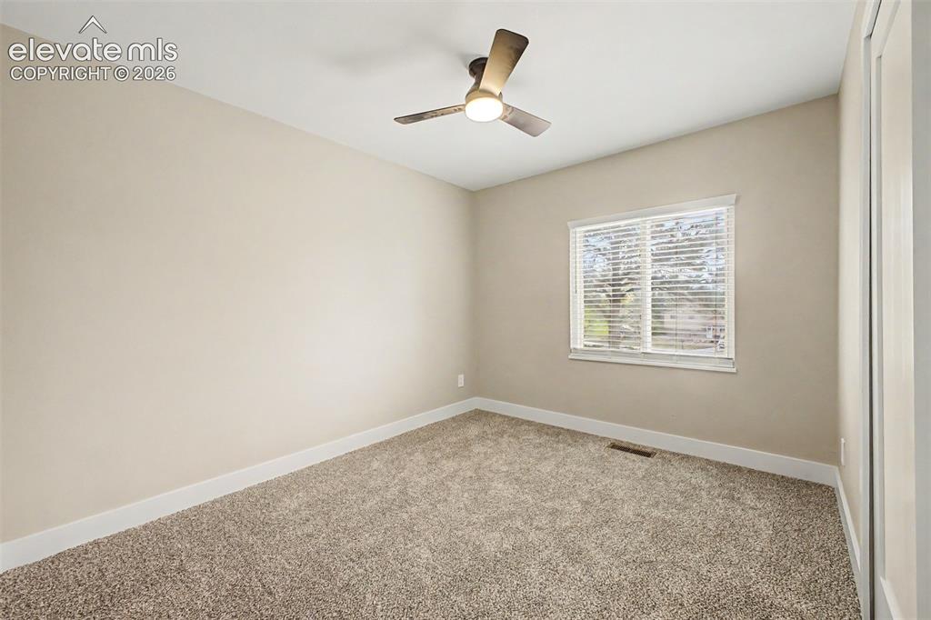 Image 18 of 36: Neutral-toned walls, vaulted ceiling with a modern ceiling fan, large windo