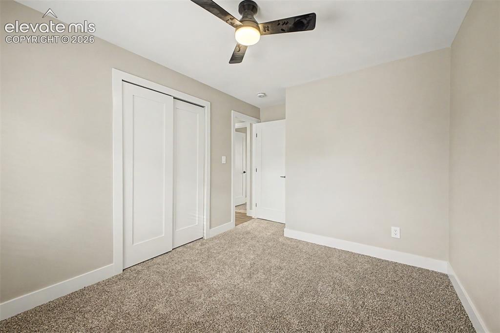 Image 19 of 36: Neutral-toned walls, plush carpet, recessed lighting, and a ceiling fan wit