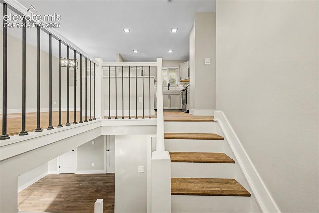 Image 2 of 36: Multi-level interior featuring wood-finish flooring, white painted walls, a