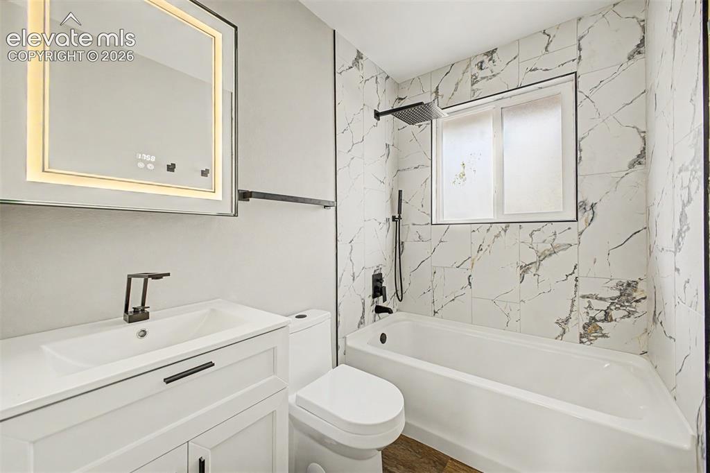 Image 20 of 36: Bathroom featuring a white vanity with integrated sink, contemporary black 