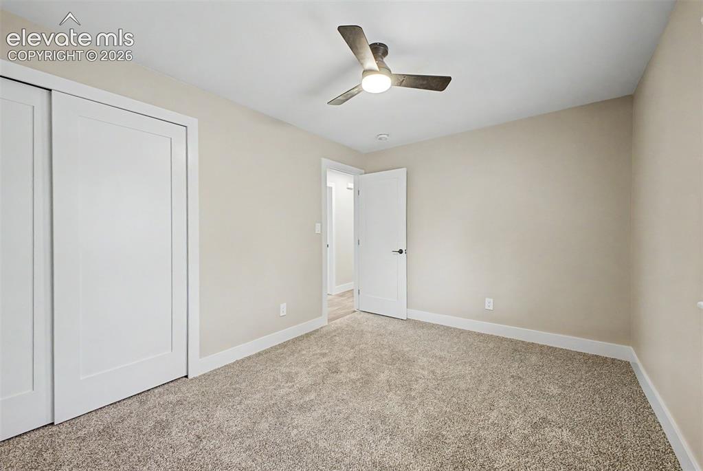 Image 26 of 36: Neutral-toned carpeting, white walls, and a modern ceiling fan with integra