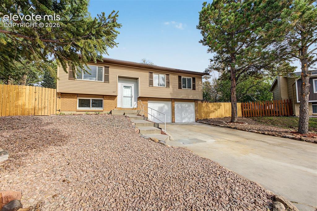 Image 29 of 36: Two-story residence featuring light brown siding and brick accents