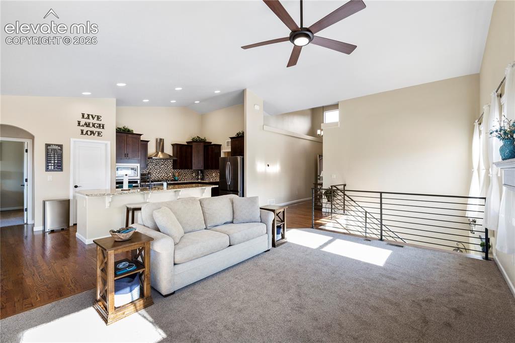 Image 12 of 39: Vaulted ceilings featuring a central overhead fan, dark wood-finish cabinet