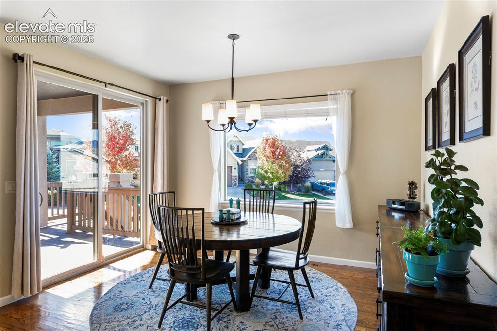Image 9 of 39: Dining area featuring wood-finish flooring, a multi-light chandelier, a lar